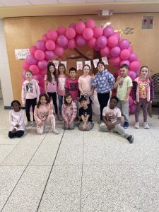Group of students standing in front of a pink display for Pink Shirt Day