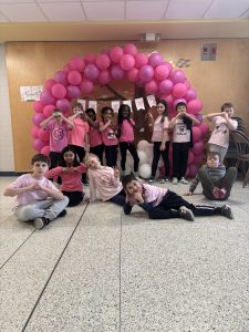 Group of students standing in front of a pink display for Pink Shirt Day