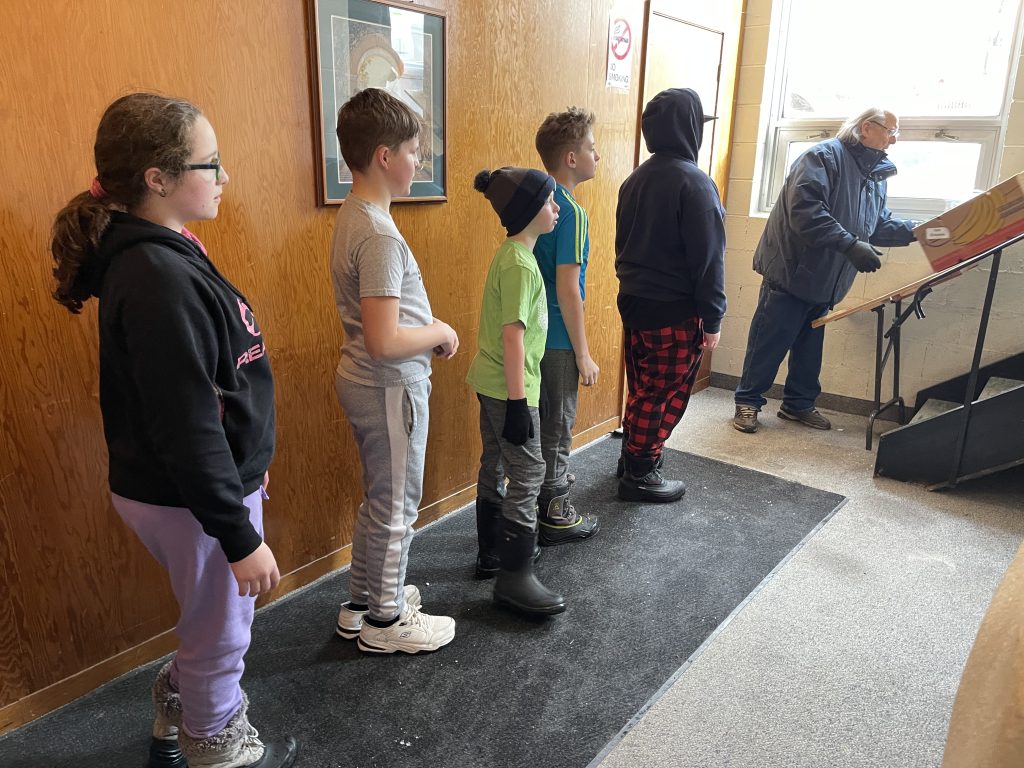 students lined up to help unload truck at food bank