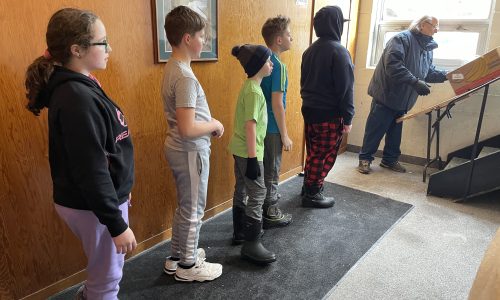 students lined up to help unload truck at food bank