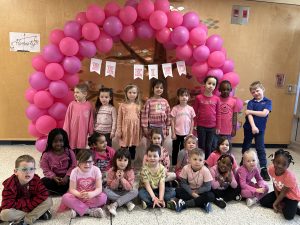 Group of students standing in front of a pink display for Pink Shirt Day