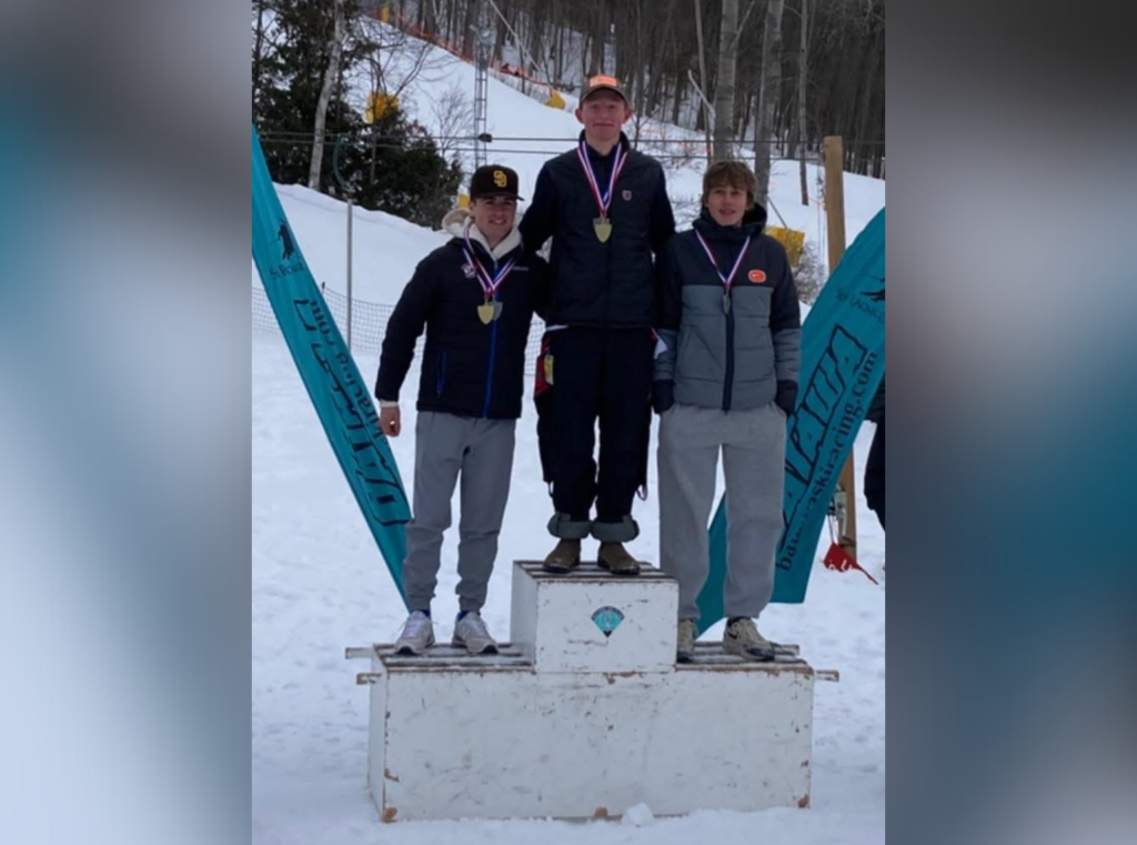 Three male teens standing on a podium