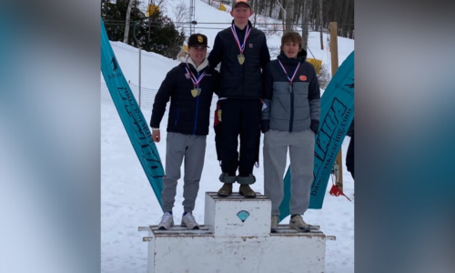 Three male teens standing on a podium