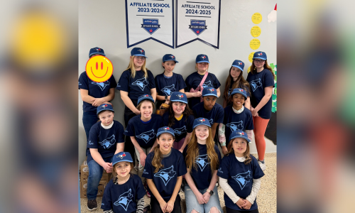 Students pose for a photo in front of two Jays Care banners.