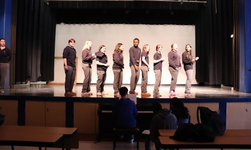 Students hold a rehearsal for a musical at a school.