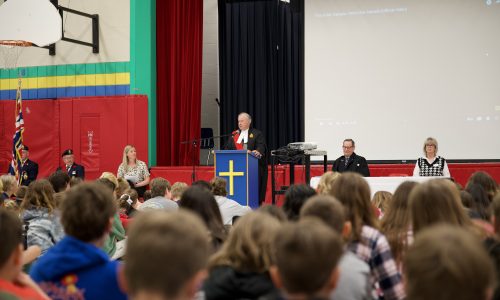 A judge presides over a school gymnasium that has been transformed into a courtroom for a citizen reaffirmation ceremony.