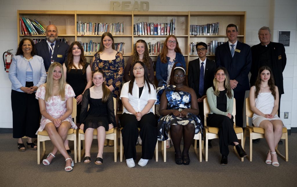 A group of students and adults pose for a group photo.