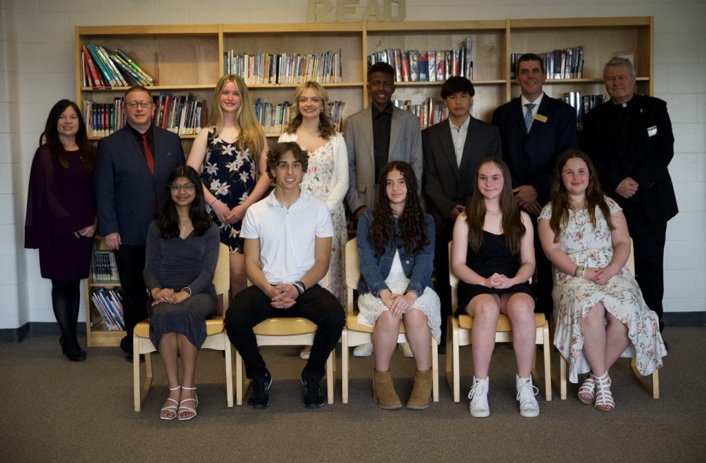 A group of students and adults pose for a group photo.