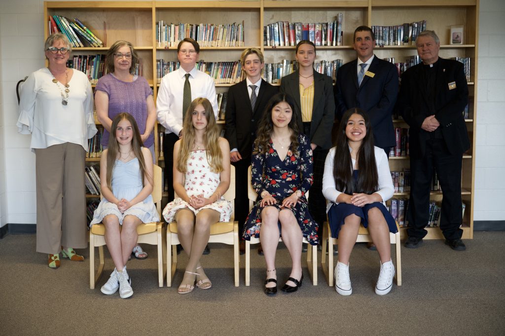 A group of students and adults pose for a group photo.
