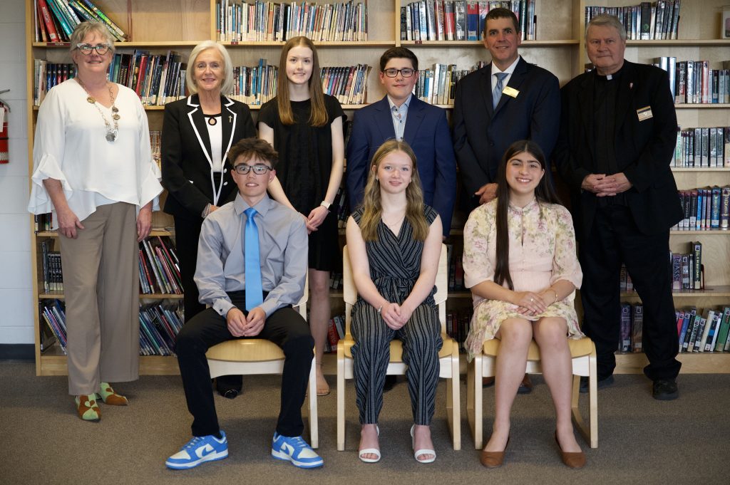 A group of students and adults pose for a group photo.