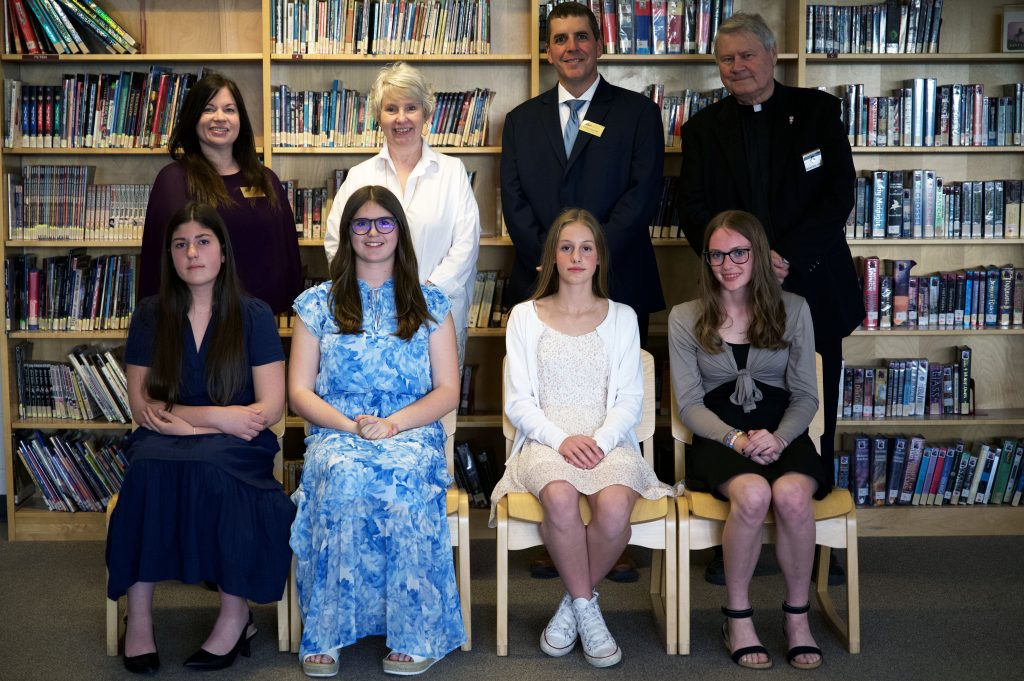 A group of students and adults pose for a group photo.