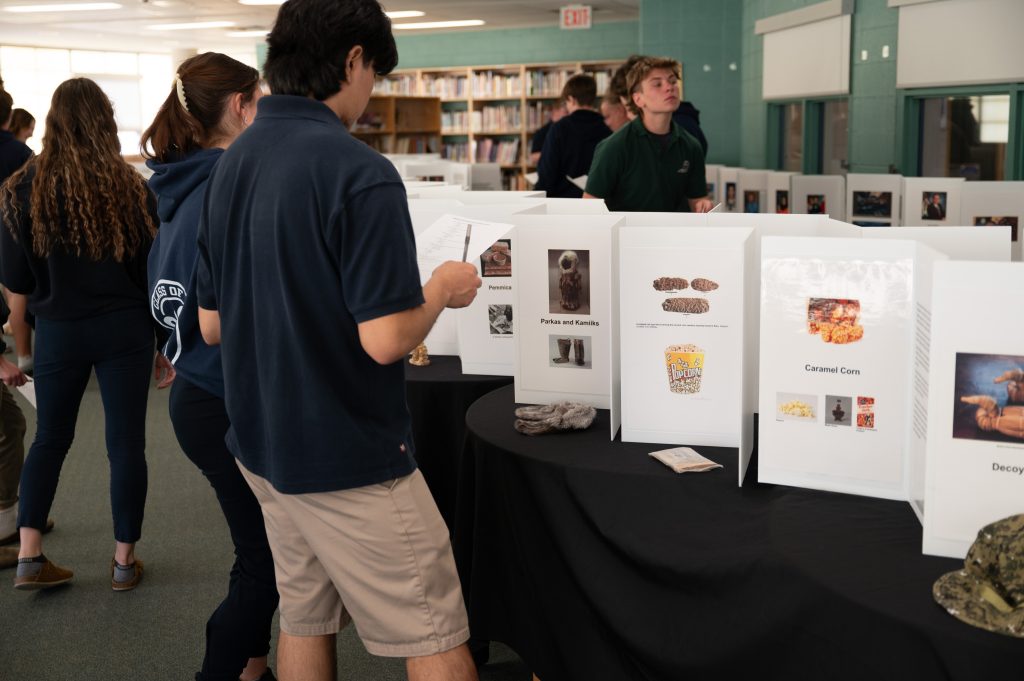 Students look at displays of inventions at a museum.
