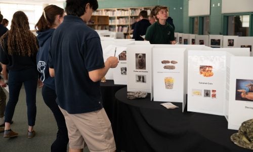 Students look at displays of inventions at a museum.