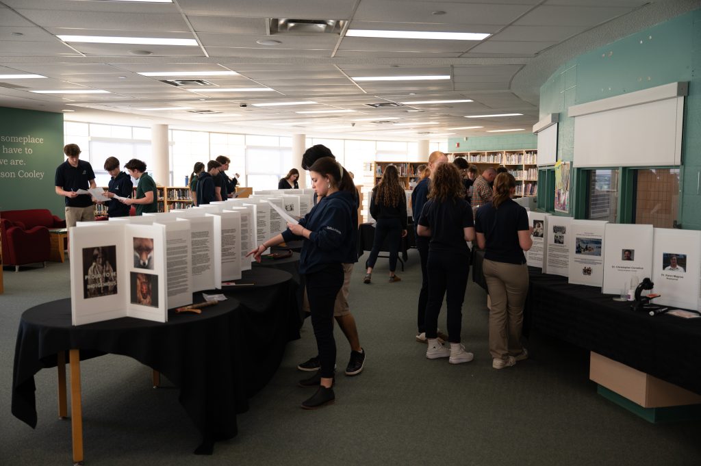Students look at displays of inventions at a museum.