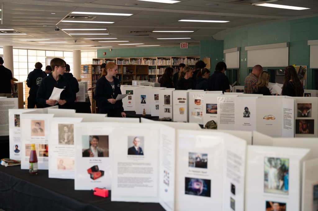 Students look at displays of inventions at a museum.