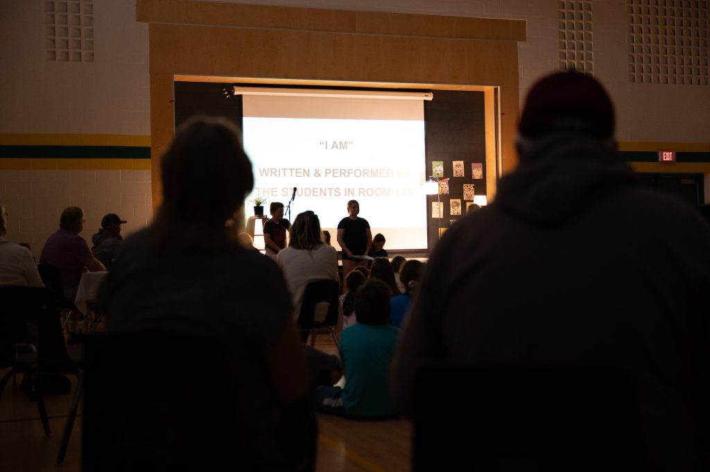 Poetry assembly in a school gymnasium.