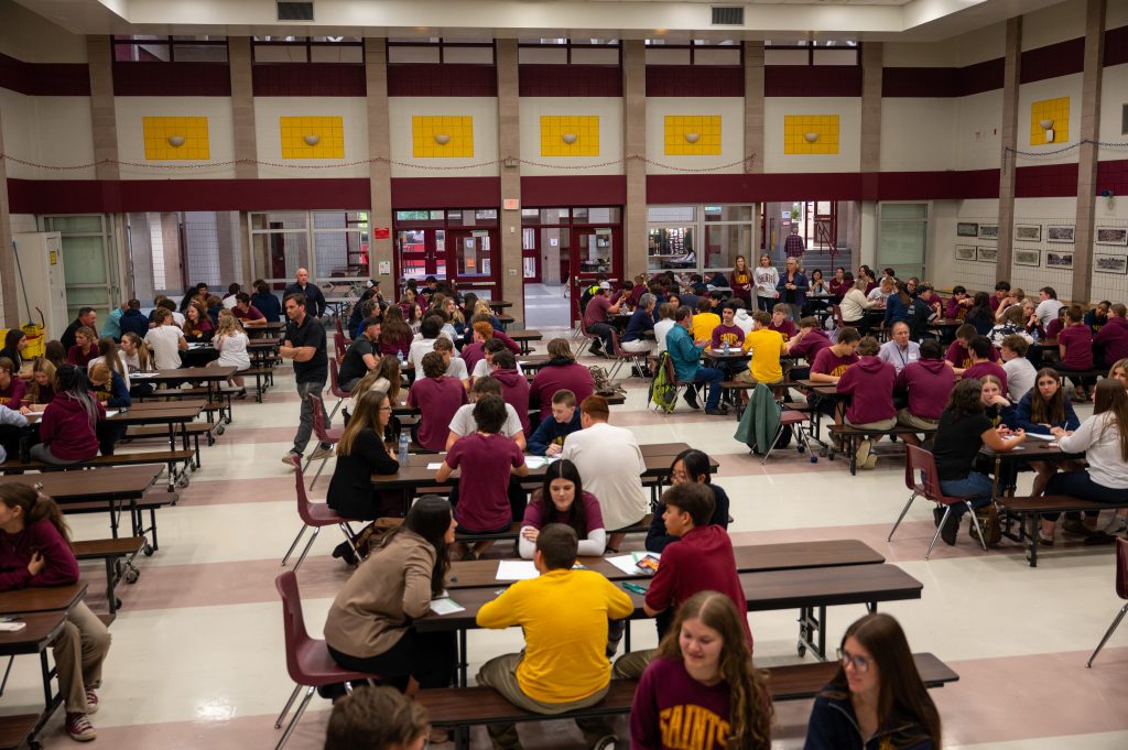 A large group of students attend career coaching event in school cafeteria.