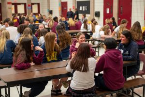 Group of students receive career coaching from industry professional at school assembly.