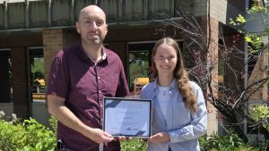 Student poses with adult after receiving bursary.
