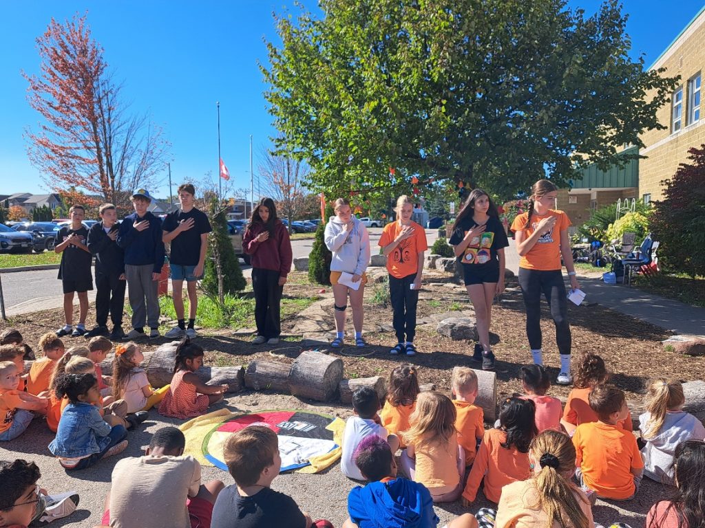 Students gather at a school medicine garden.