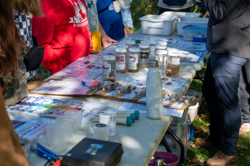 Group of students gather around a table for water testing.