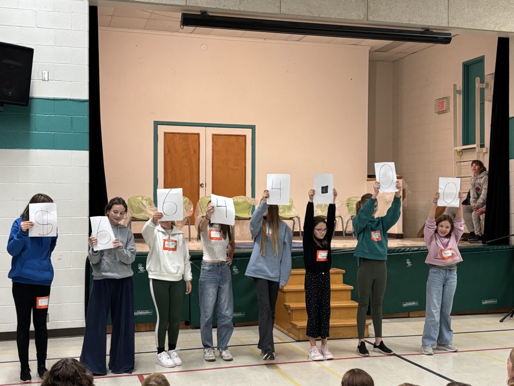 Group of students holding placcards at an assembly.