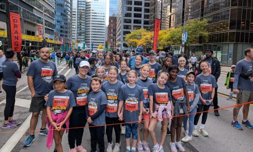 A group of children poses at a marathon.