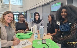 Five female students gather around a circular table at a student summit.