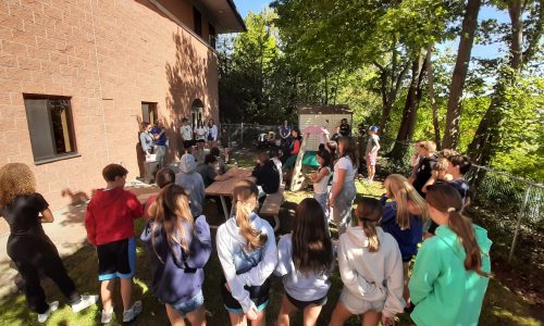 A group of students gather outdoors for a summit.