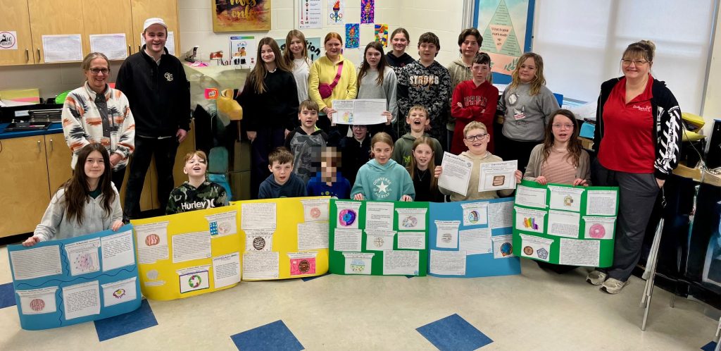 Students pose with their project boards for a photograph.