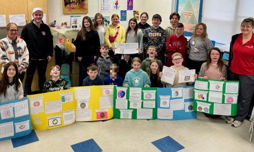 Students pose with their project boards for a photograph.