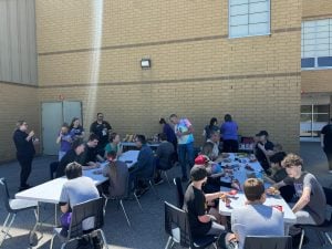 Students, teachers and their families gather for a community barbecue lunch.
