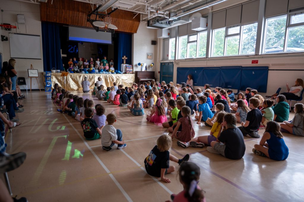 Students gather for an assembly in a school gym.