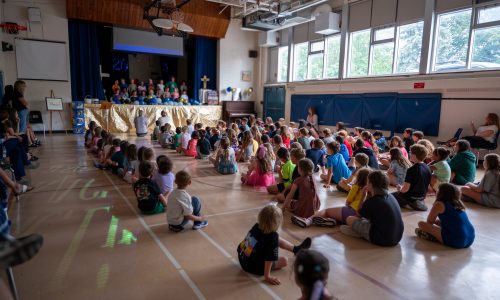 Students gather for an assembly in a school gym.